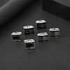 Une collection de boutons de manchette carrés rayés argent et noir, présentés sur une surface sombre.
