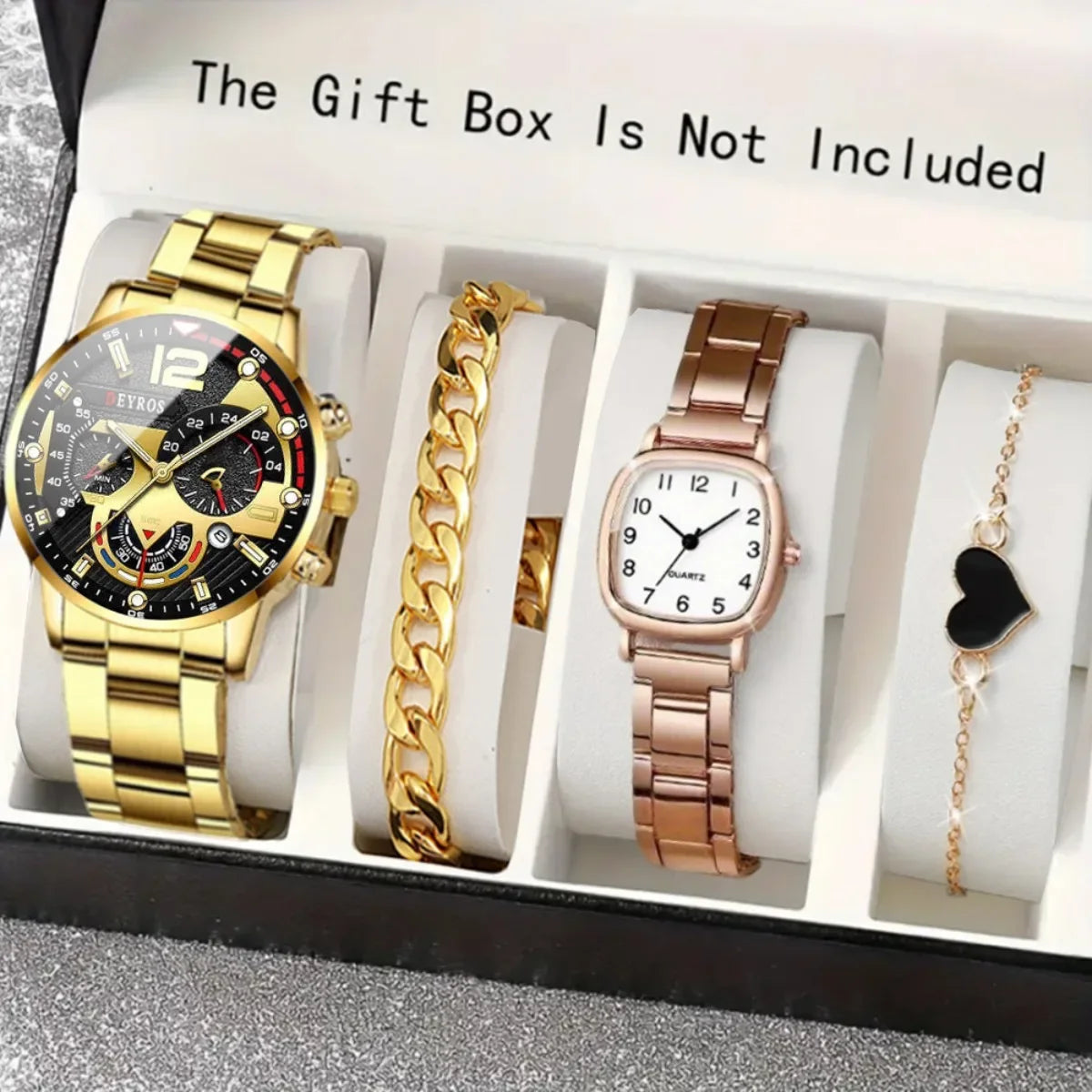 A gift box contains a gold-toned watch, a gold chain, and a rose gold watch with a heart pendant.