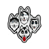 Un set de quatre épingles émaillées représentant des têtes de loups stylisées aux yeux bleus et à la fourrure blanche.