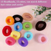 A collection of 12 multi-colored cotton elastic hair ties in various shades are displayed on a pink surface.