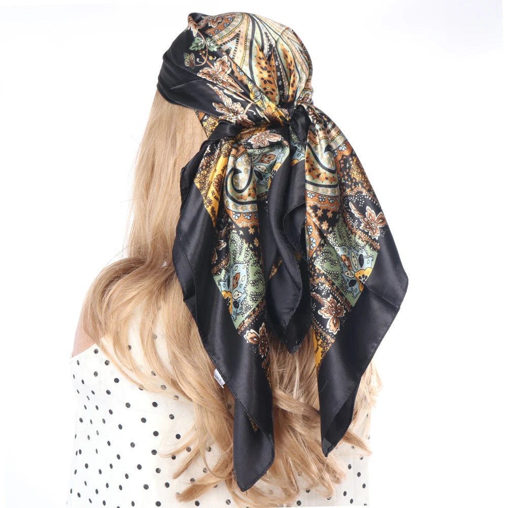Schwarzer und goldener Boho-Seiderschal, gebunden als Kopftuch um blonde Haare.