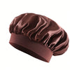 Bonnet pour cheveux en satin de soie mauve foncé plié et exposé sur fond blanc.