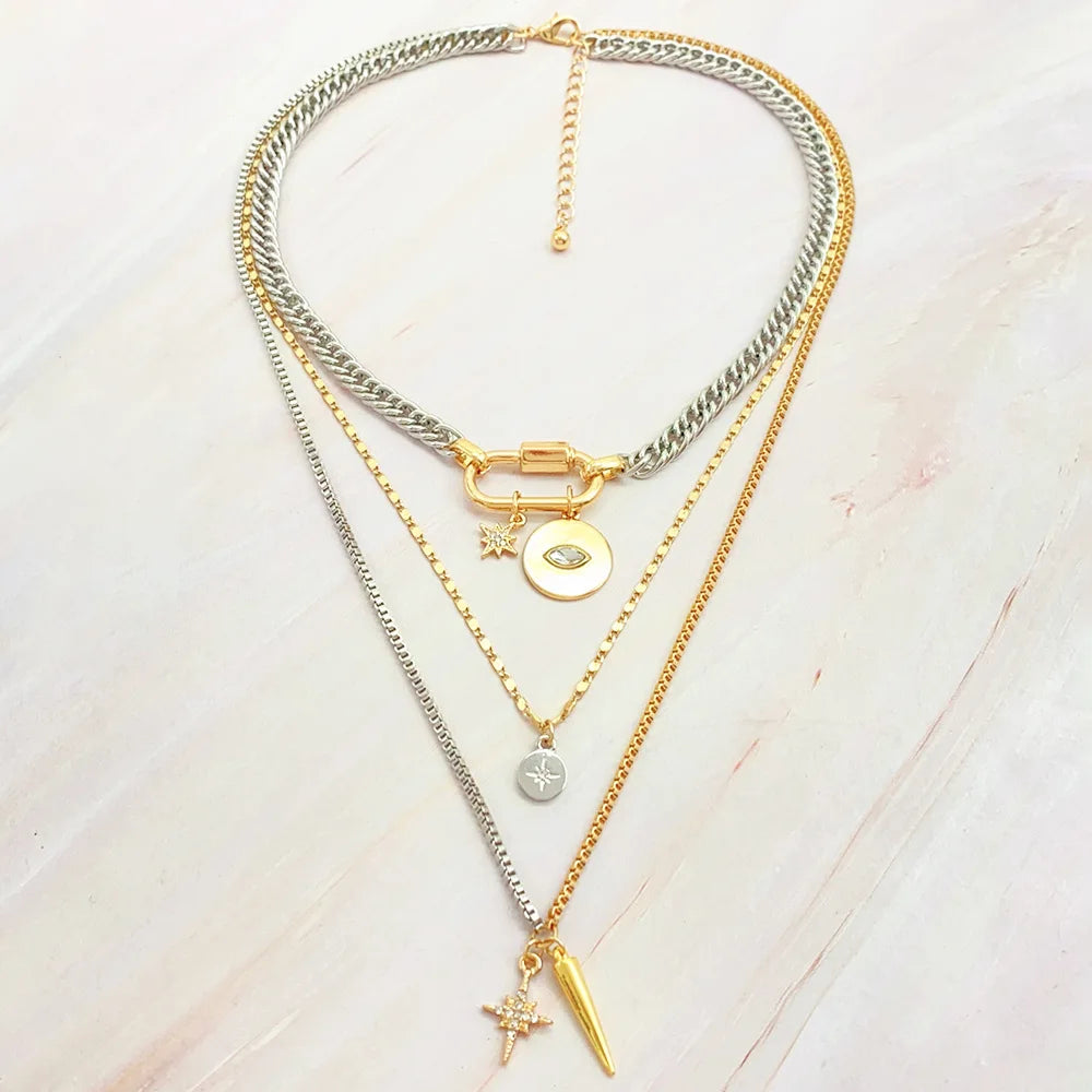 A multilayered gold and silver necklace featuring a star eye pendant and various chains.