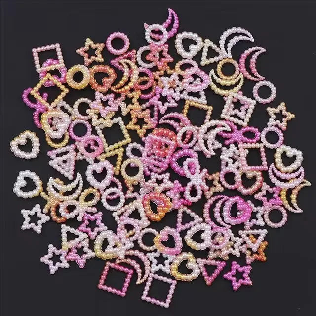 A collection of 10 pink and cream resin nail art charms featuring various shapes like stars hearts and circles