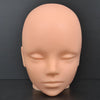 A smooth, light peach-colored professional mannequin head used for practice and display.