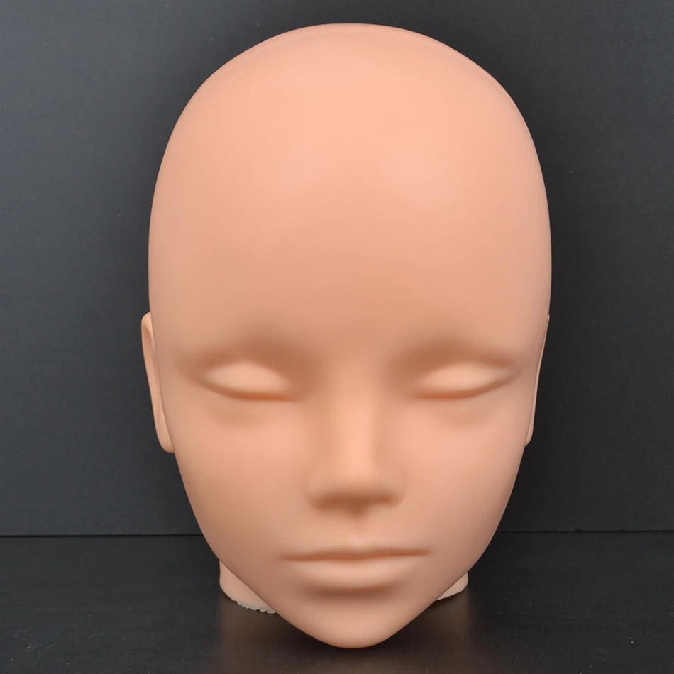 A smooth, light peach-colored professional mannequin head used for practice and display.