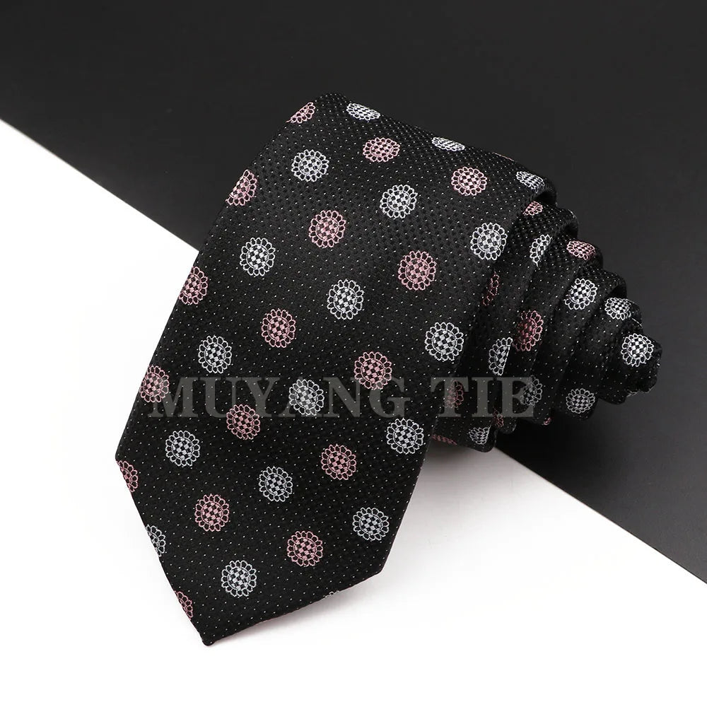 Stapel schwarzer Herrenkrawatten mit Blumen-Paisley-Muster in rosa und weißen Punkten