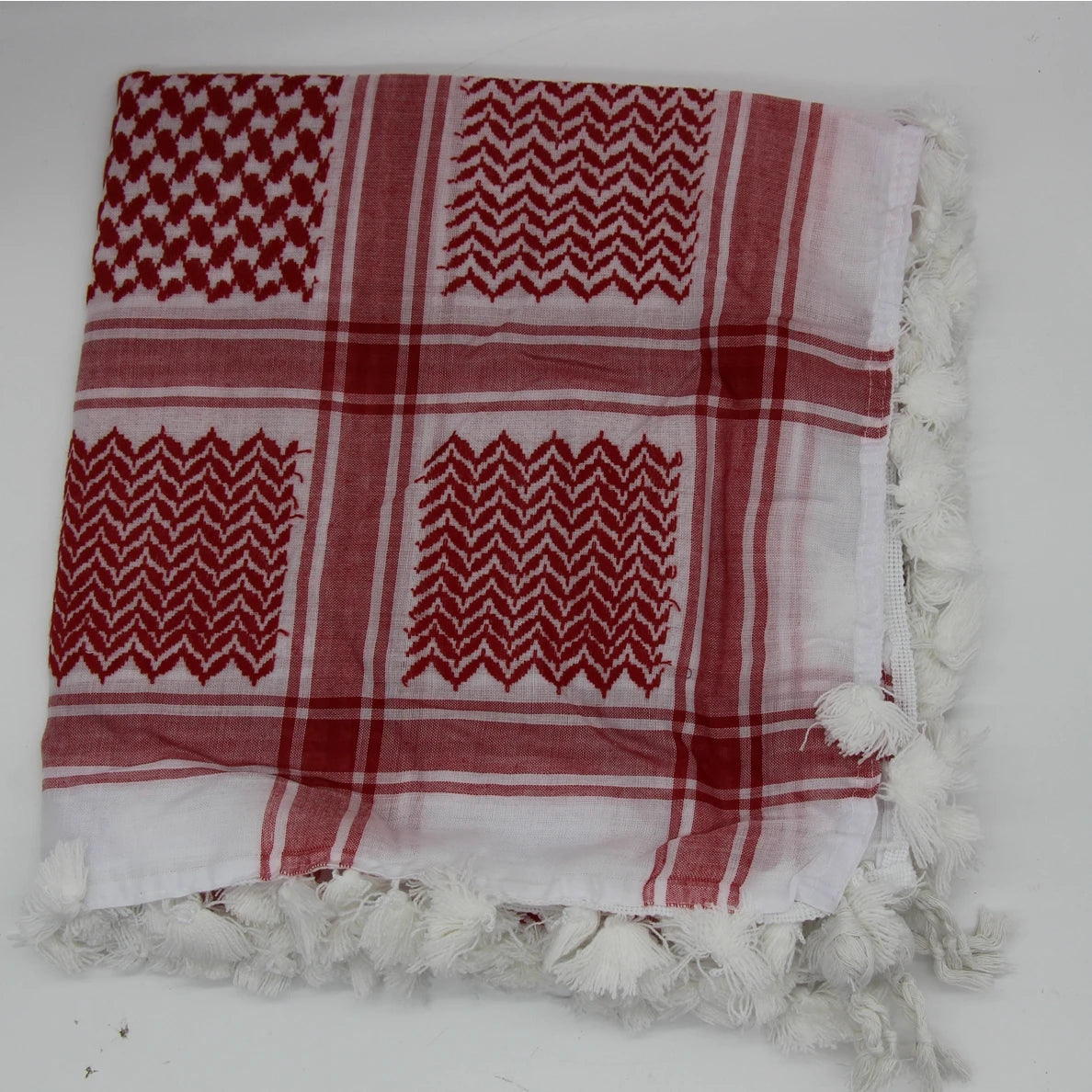 Pañuelo de algodón a cuadros rojo y blanco doblado con flecos blancos.