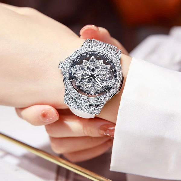 A close-up of a luxury quartz women's watch with a diamond-encrusted face and silver band worn on a wrist.