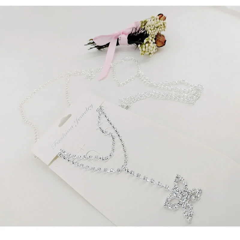A delicate silver crystal diamond waist belt with a floral ribbon and a sparkling butterfly charm.