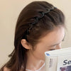 A close-up of a woman wearing a brown resin wave toothed headband in her dark hair.