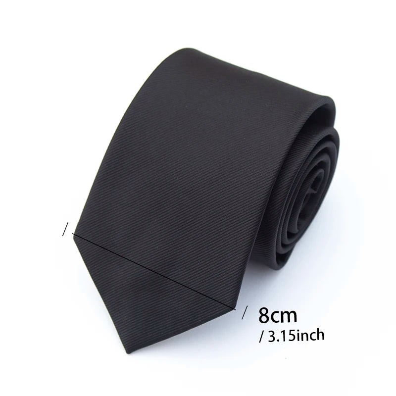 A solid black necktie rolled into a narrow, rectangular shape with a measurement of 8cm or 3.15 inches.