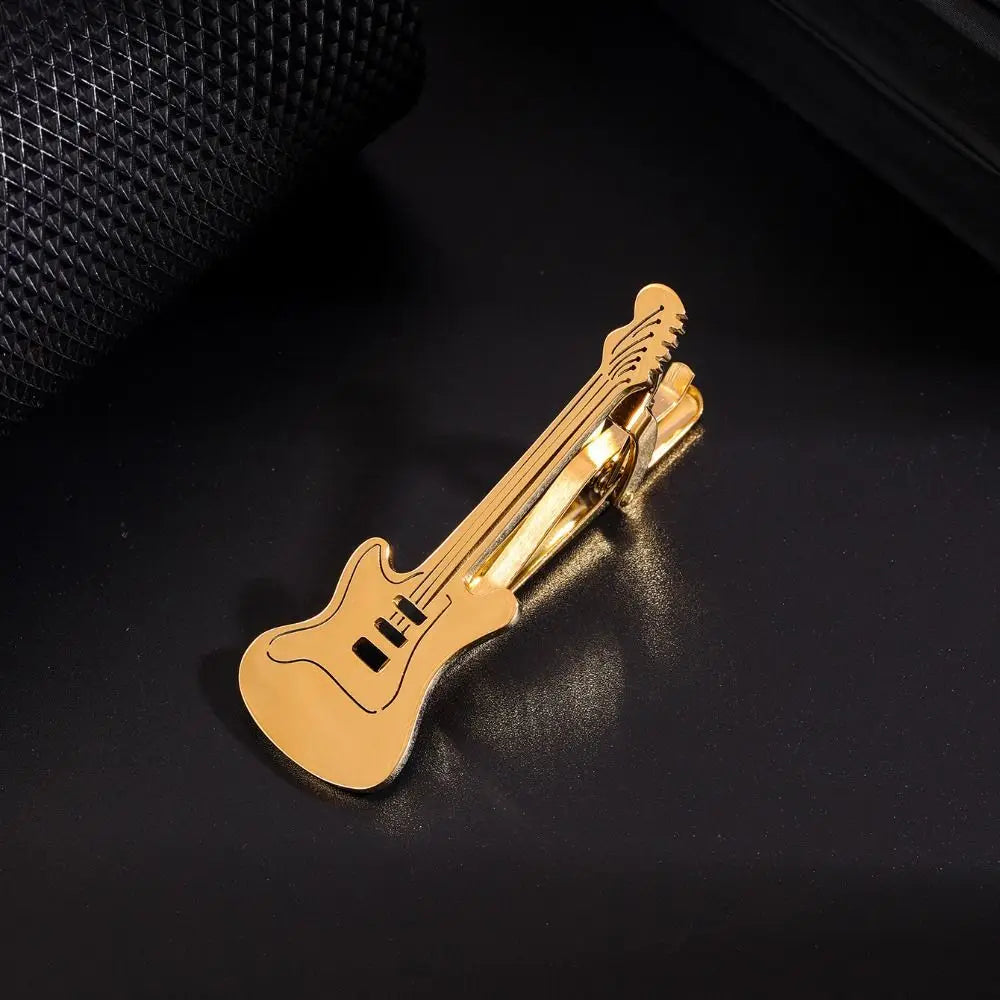Goldfarbiger Titan-Kettchen in Gitarrenform, auf einer dunklen Oberfläche.