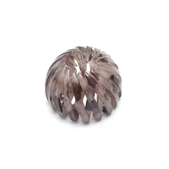 A close-up of elegant silver-toned horsetail hair clips with a twisted, textured design.