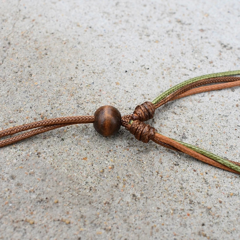 A set of boho vintage wood bead necklaces featuring brown and olive green cord tied together.