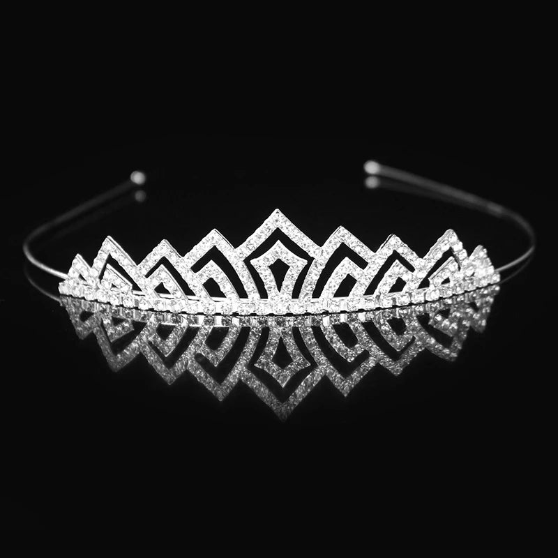 Tiara y corona de princesa de cristal brillante, accesorio para el pelo, reflejándose en una superficie oscura.