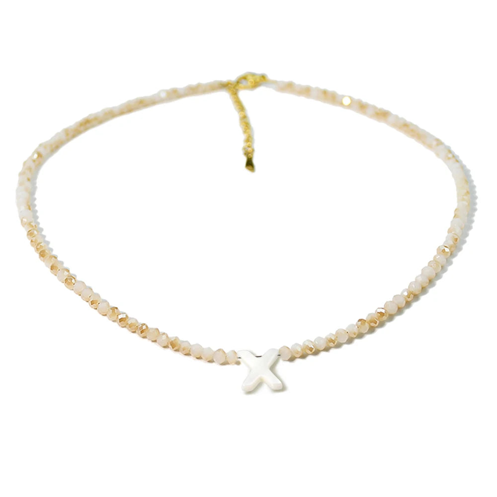 A delicate necklace made of mother of pearl beads with crystal accents and a cross pendant.
