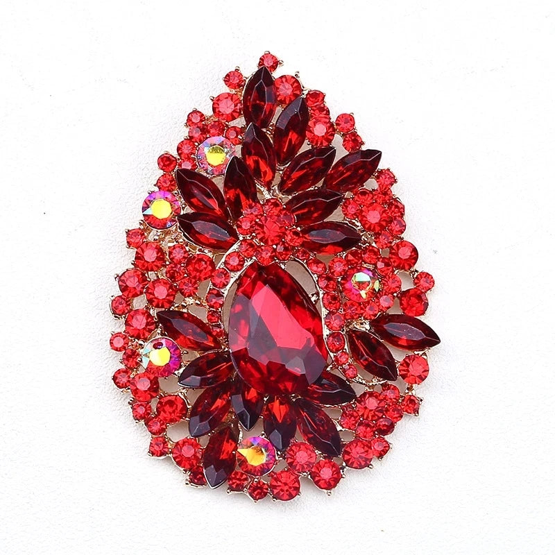 Broche fleur en cristal rouge brillant avec de nombreuses petites pierres rouges et claires.