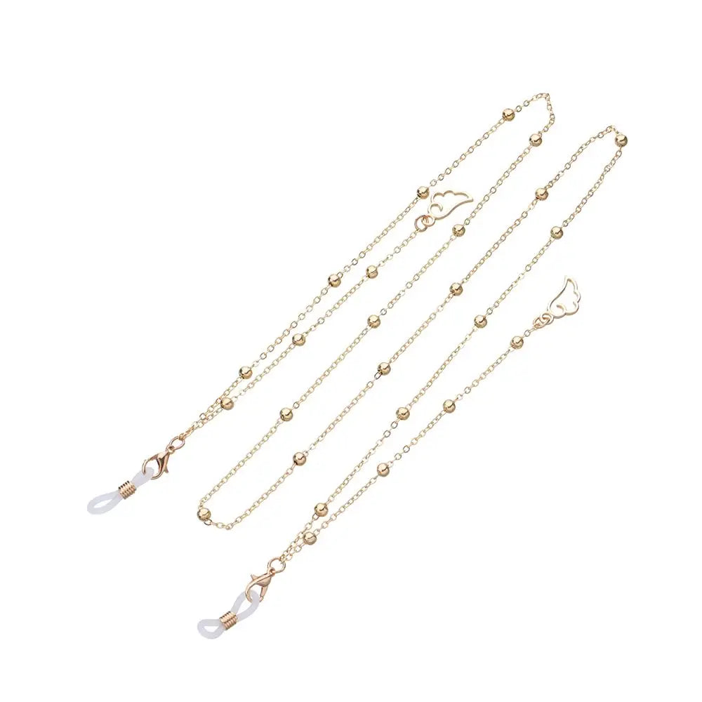 A delicate gold-colored chain with a hollow star pendant used as an eyeglass lanyard.