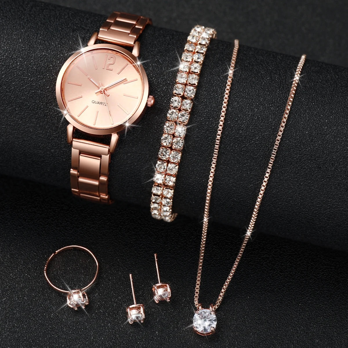 A set of rose gold quartz wrist watch, a matching bracelet, and a delicate necklace with diamond pendants.