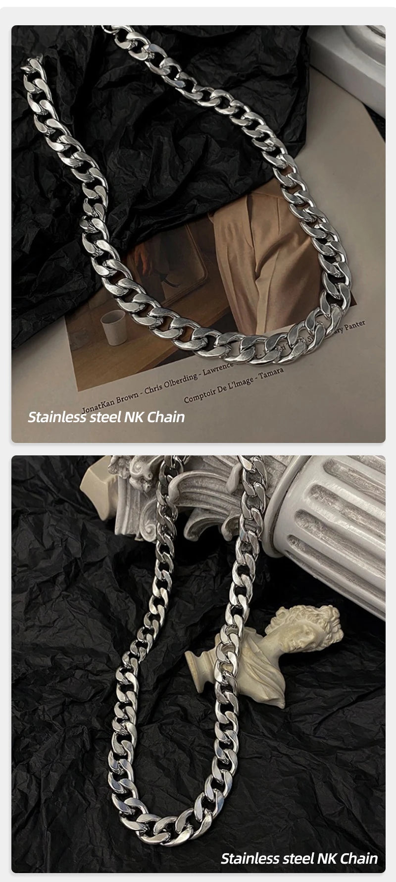 A close-up of a stainless steel NK chain necklace draped over dark fabric and next to a light-colored sculpture.