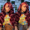 Close-up photo of a woman with long, wavy burgundy hair wearing a colorful patterned top.