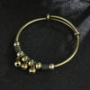 Vintage brass bell charm bracelet with a gold-toned ring and several small brass bell charms.