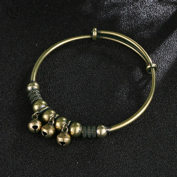 Bracelet charm à cloche en laiton vintage avec une bague dorée et plusieurs petites cloches en laiton.
