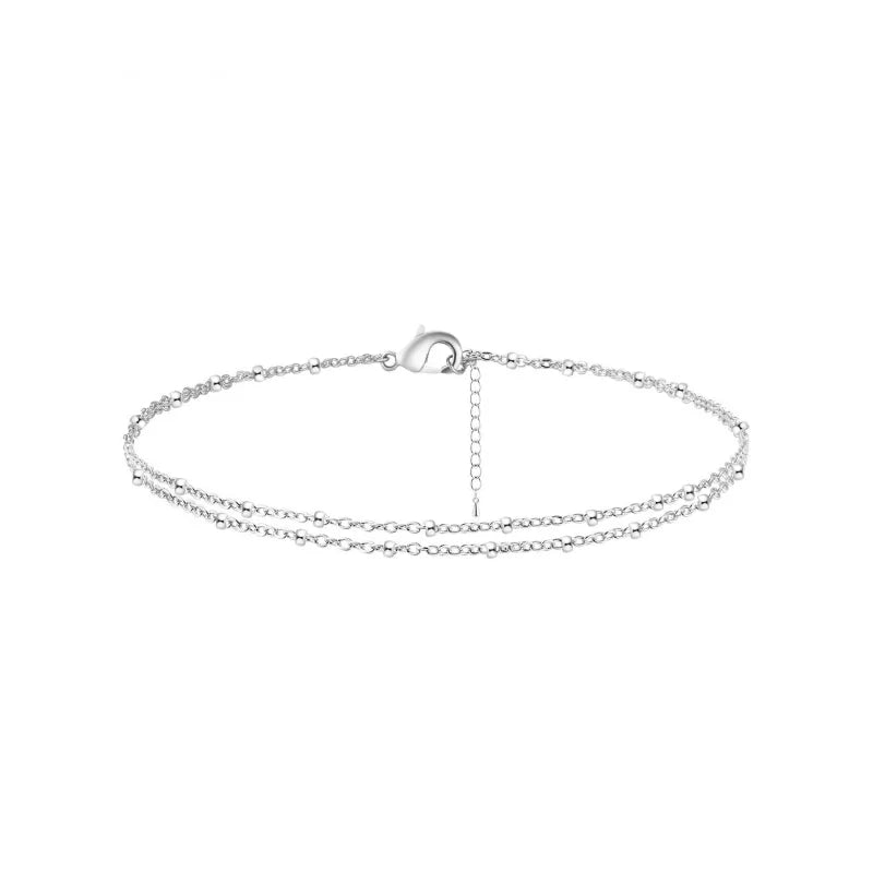 Pulsera ajustable de oro y acero inoxidable para tobillo, vista aplanada.