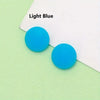Two bright blue silicone grips for eyeglasses on a light green background.