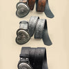 A collection of heart-shaped retro embossed leather belts in various shades of brown and black.