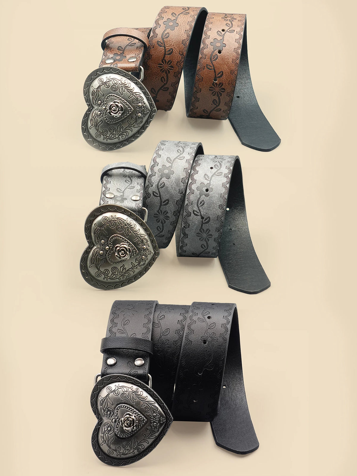 A collection of heart-shaped retro embossed leather belts in various shades of brown and black.