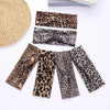 A collection of leopard print fashion headbands in various sizes and patterns laid out on a white surface.