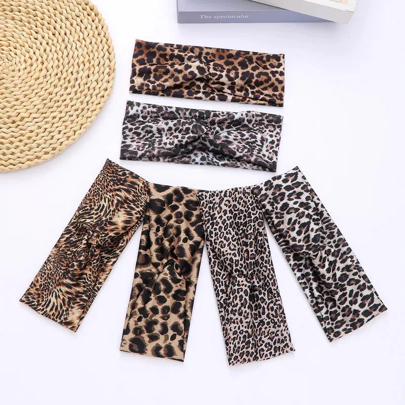 A collection of leopard print fashion headbands in various sizes and patterns laid out on a white surface.