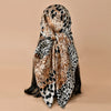 A square satin scarf featuring a leopard print pattern in shades of brown, black, and cream.
