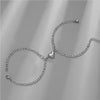 A silver stainless steel heart magnetic bracelet set displayed against a gray background.
