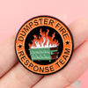 An enamel lapel pin featuring a cartoon fire on a dumpster with the text Dumpster Fire Response Team.