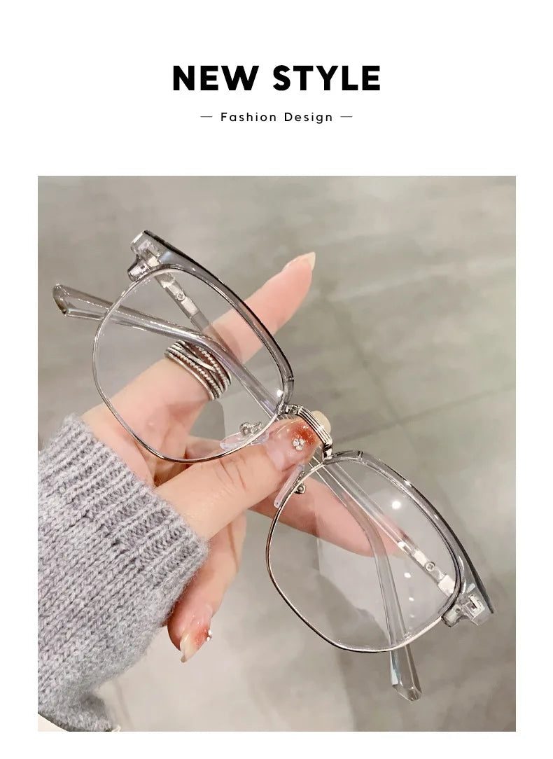 Une main tient une paire de lunettes photochromiques anti-lumière bleue claires.