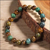 Bracelet avec des perles de citrine et d'œil de tigre sur une surface en bois.