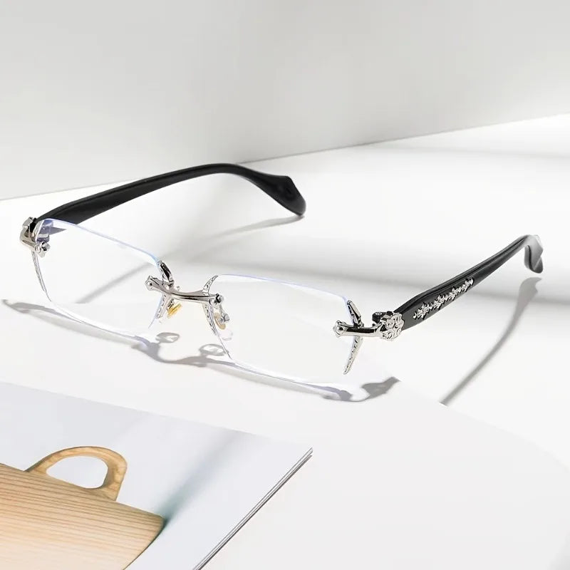 A pair of clear framed glasses with black arms and diamond-edged detailing resting on a white surface.