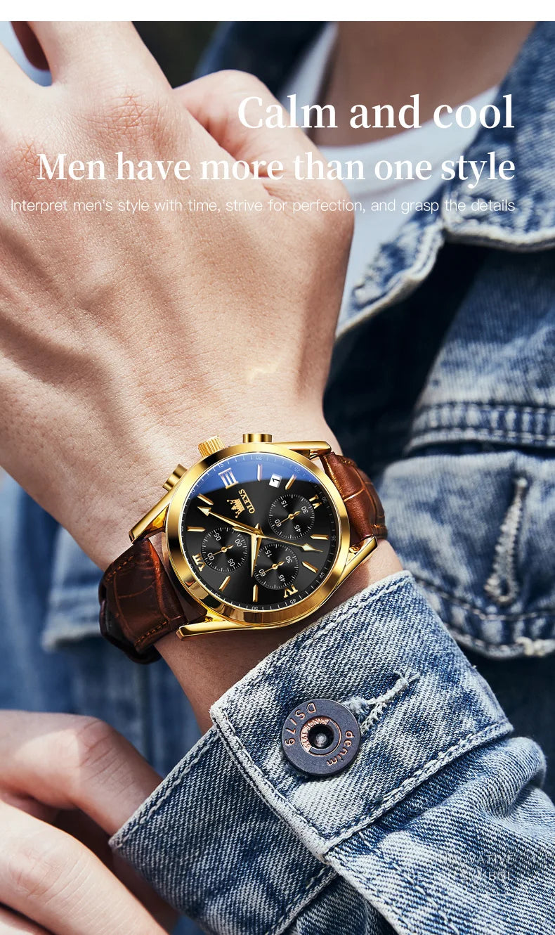 A close-up of a gold chronograph wristwatch with a dark face and brown leather strap worn on a wrist against a denim shirt.