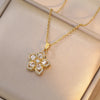 Collier en or avec pendentif de fleur zircon brillante, présenté sur une boîte beige clair.