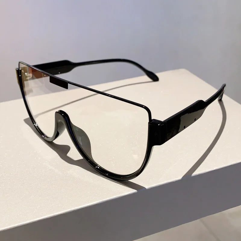 Black vintage cat eye sunglasses with clear lenses resting on a white surface.