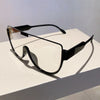 Black vintage cat eye sunglasses with clear lenses resting on a white surface.