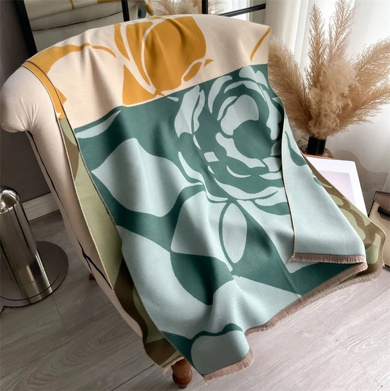 A light sage green and mustard yellow plaid cashmere scarf draped on a surface.