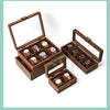 A wooden watch and jewelry display box with multiple slots for showcasing watches and accessories.