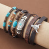 A stack of handcrafted retro western beaded bracelets featuring brown leather and turquoise beads on a wrist.