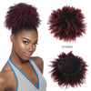 Model präsentiert eine rötlich-violette lockige Haarverlängerung im Afro-Puff-Chignon vor weißem Hintergrund.