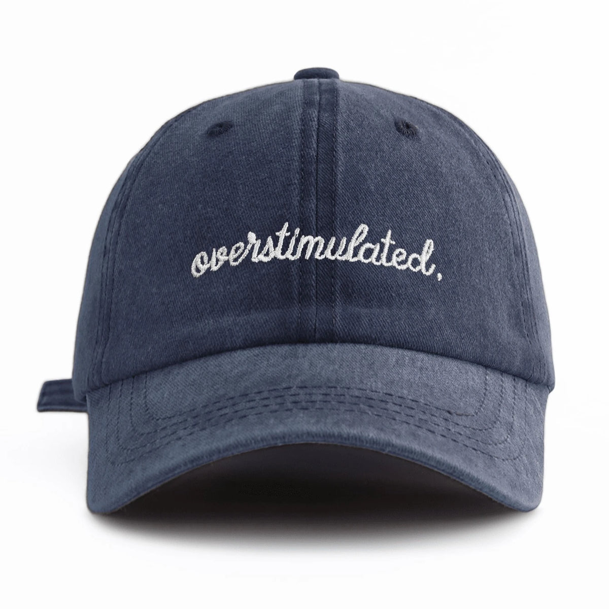 A dark navy washed baseball cap embroidered with the word overstimulated