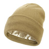 A beige knit beanie hat with a satin lining, shown from the side.